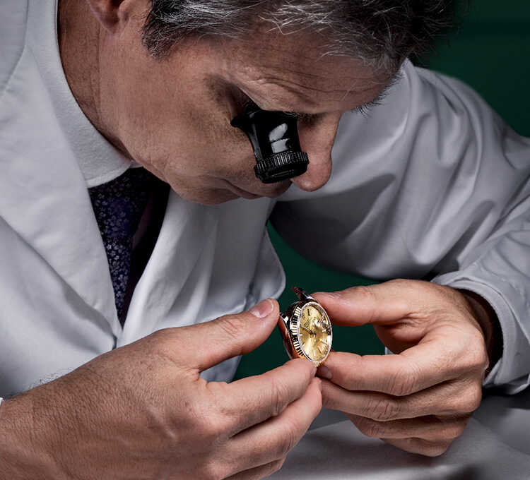 Image of man delicately inspecting Rolex watch